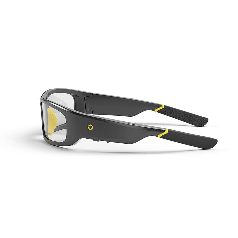 A pair of Lucyd Armor | Slim Photochromic eyewear by Lucyd, featuring sleek black frames, clear lenses, yellow accents, and padded temples, rests on a white surface.